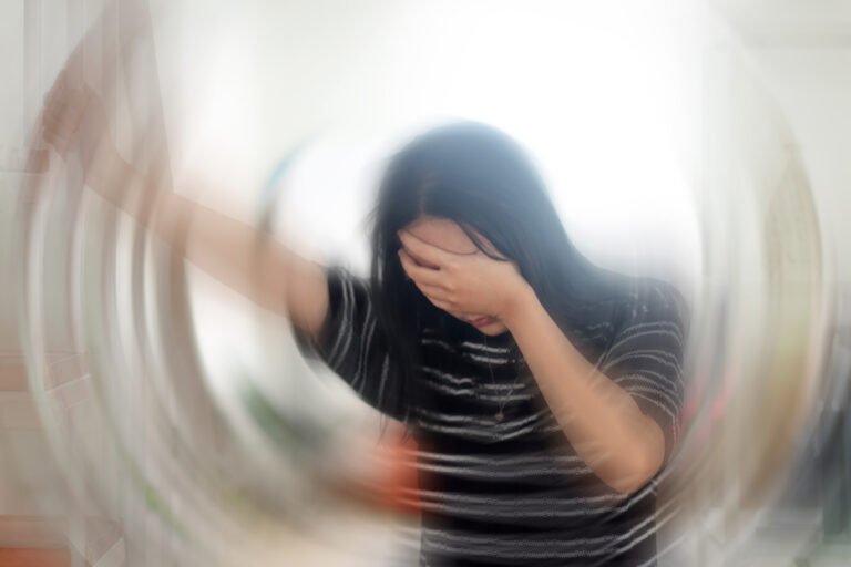 Portrait Of Young Woman Suffering From Vertigo Or Dizziness With Blurred