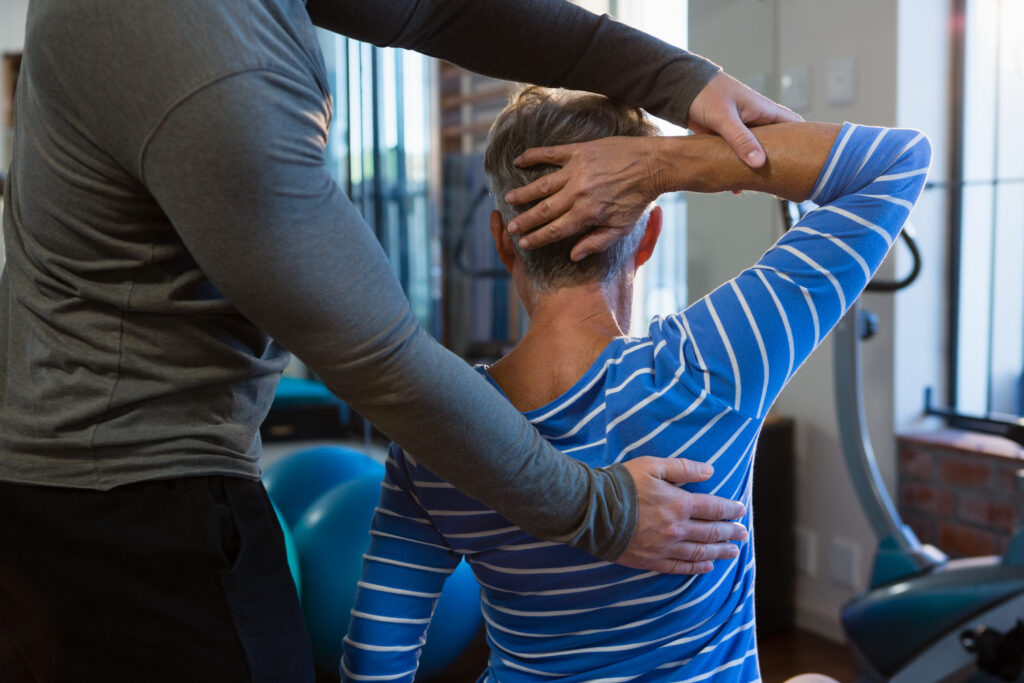 Physiotherapist assisting a senior woman with exercise at the clinic