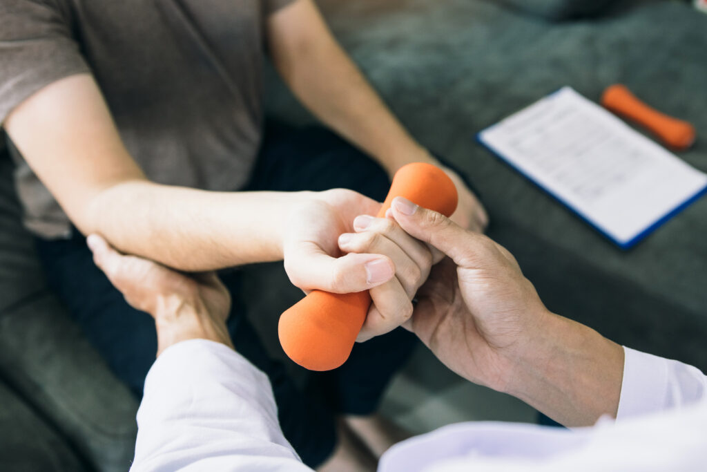 Physiotherapist helping a patient raise her arms during therapy