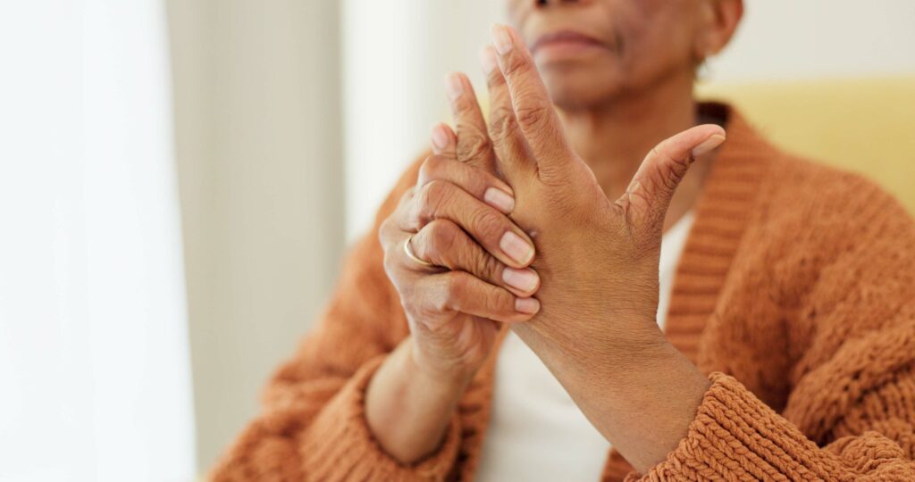 Elderly woman experiencing hand pain from arthritis