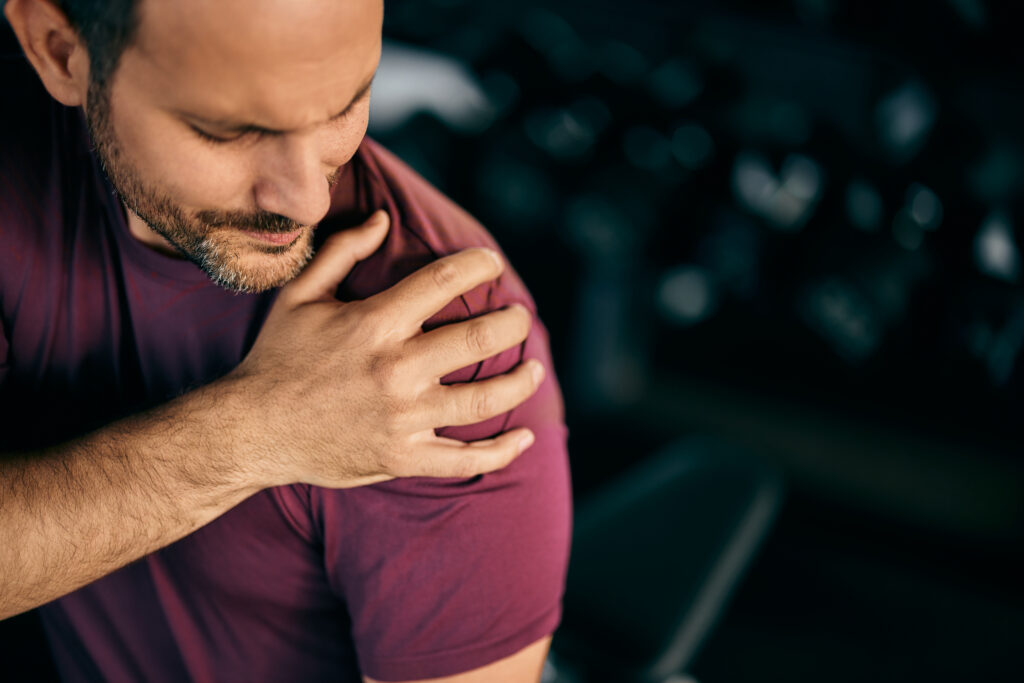 Man experiencing shoulder pain after an injury during a workout