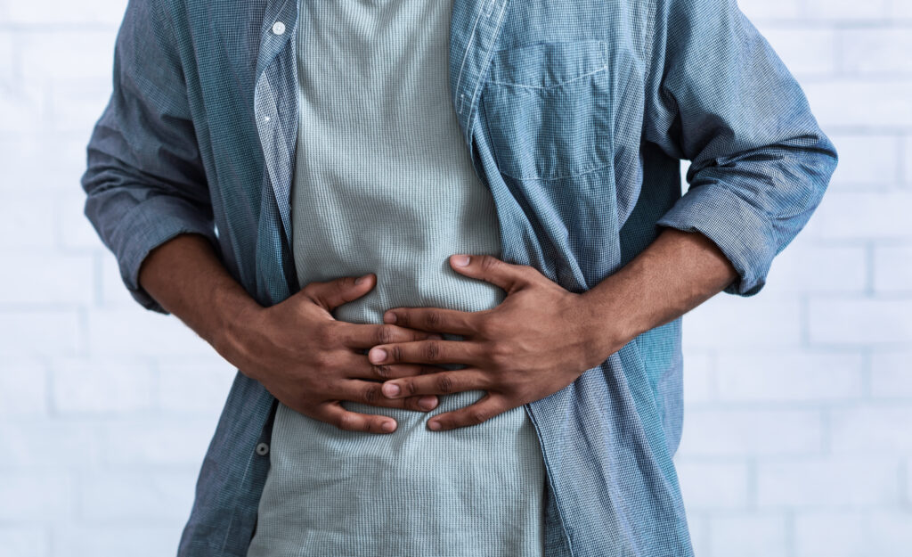 Man holding his stomach in discomfort, representing bloating and post meal digestive discomfort at Mast Health in Tampa