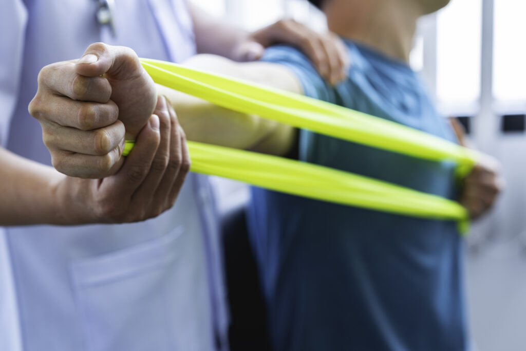 Physical therapist guiding a patient through resistance band exercises