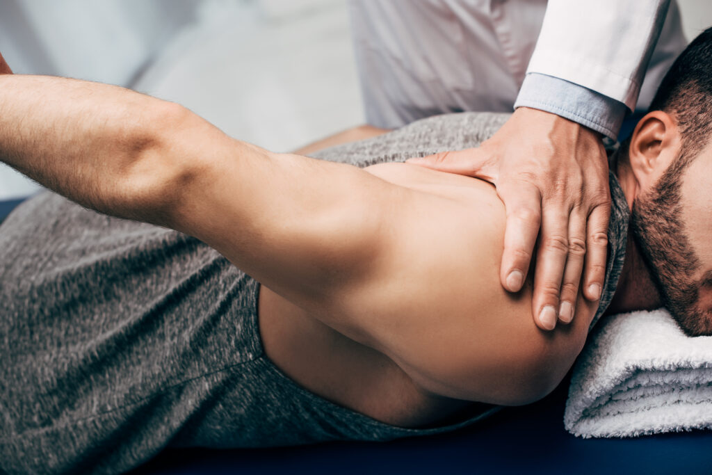 Physiotherapist stretching a patients arm to relieve arthritis pain