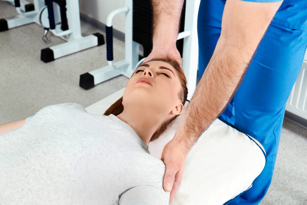 Physical therapist supporting a patient's head and neck during rehabilitation therapy, herniated disc care Mast Health provides in Tampa