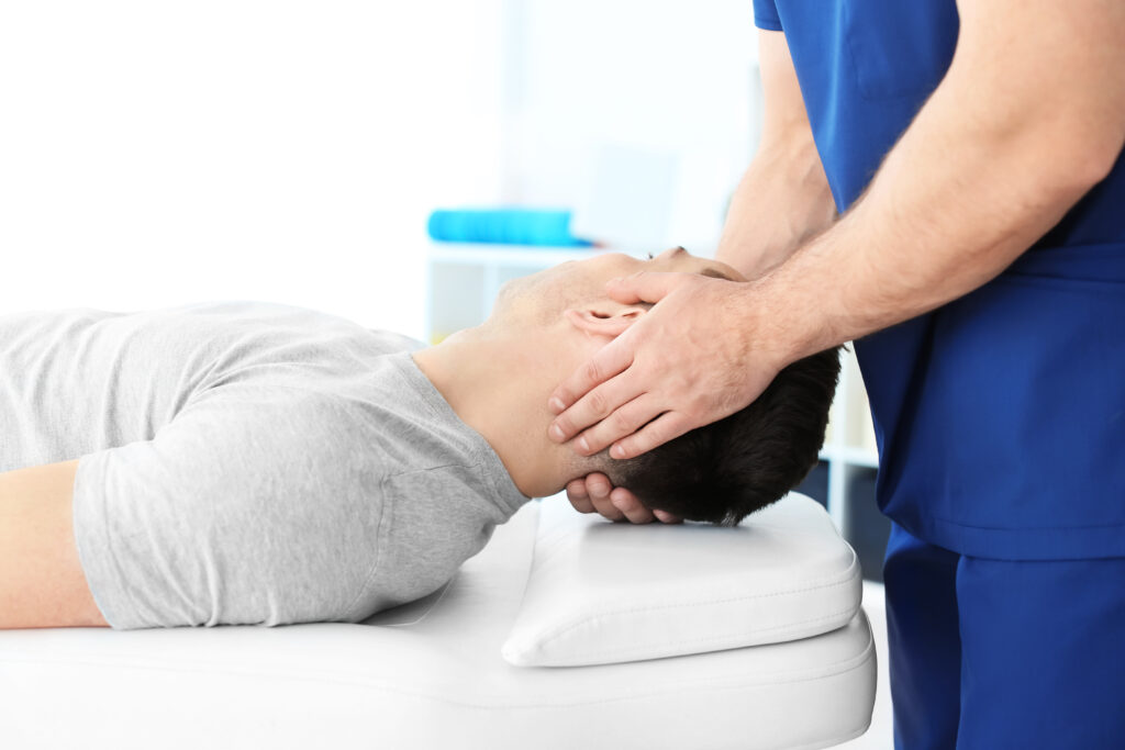 Physical therapist using hands-on technique to relieve a patient's neck tension, cervicogenic headache relief Mast Health provides in Tampa