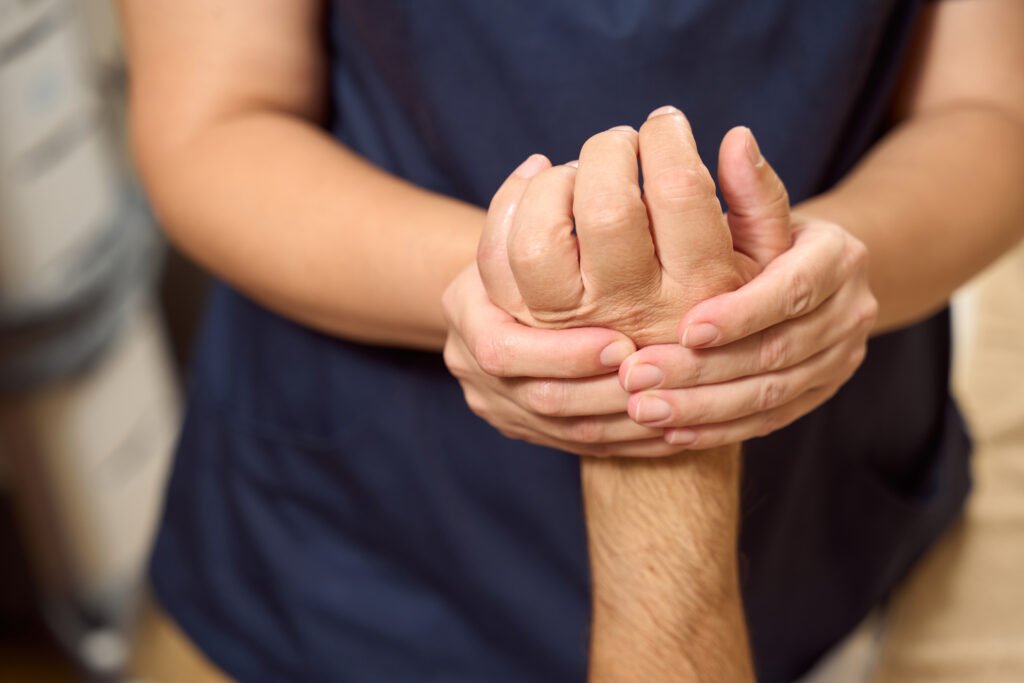 Massage therapist kneading a patients back in a treatment room