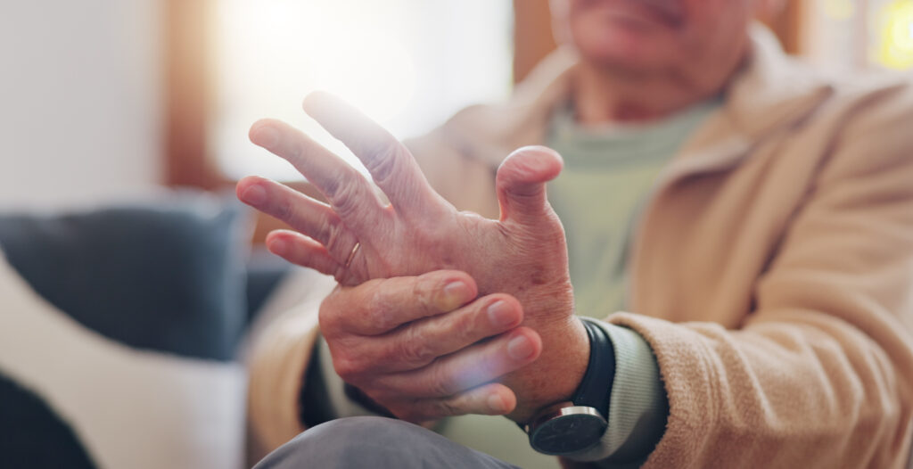 Senior man massaging his hand due to autoimmune joint pain