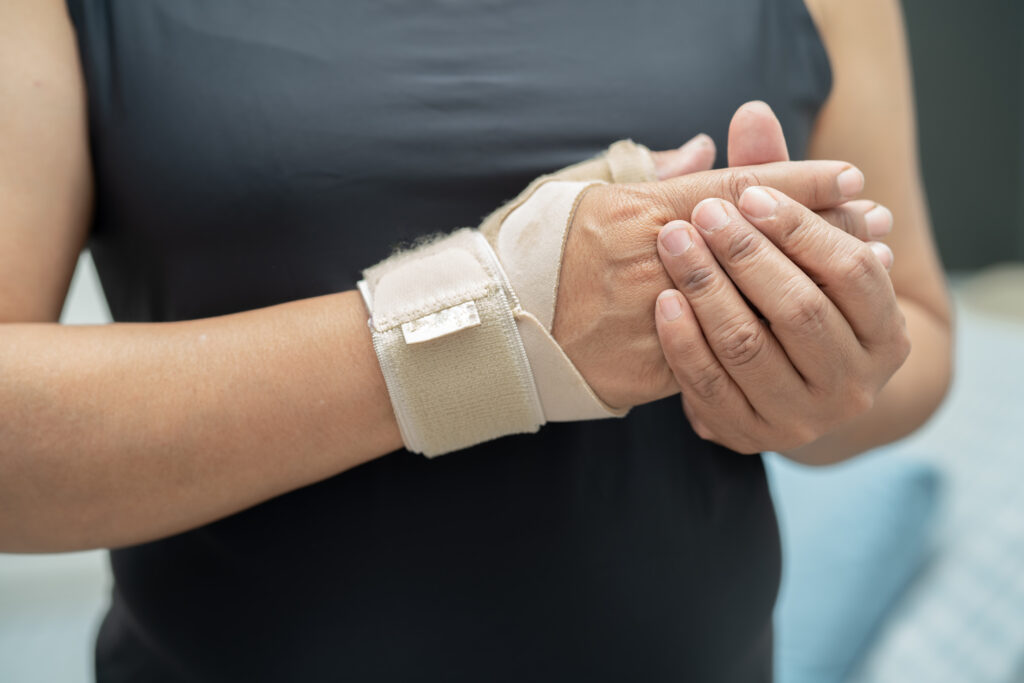 Woman using an elastic bandage to treat her wrist at home