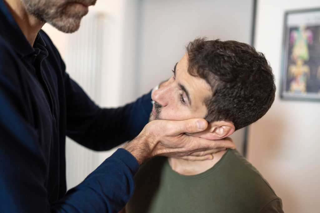 Chiropractor performing a cervical neck adjustment to relieve TMJ and jaw tension at Mast Health in Tampa, FL