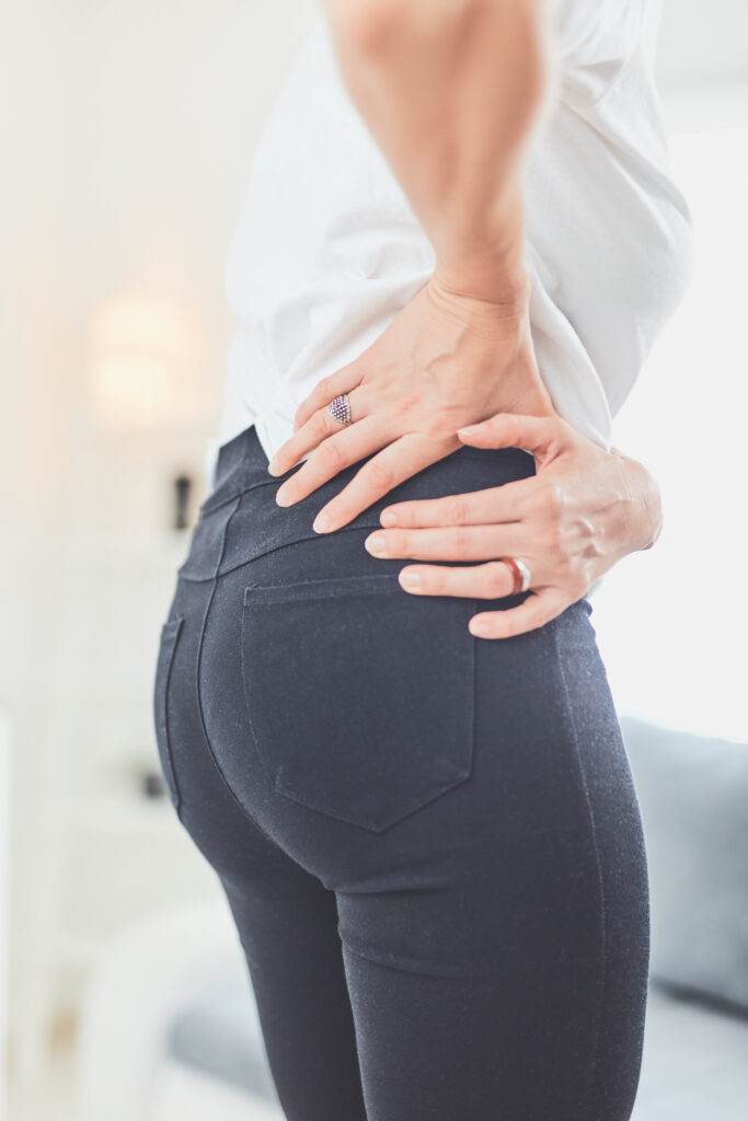 Woman clutching her hip and lower back in pain, a symptom of hip pain treated at Mast Health in Tampa, FL