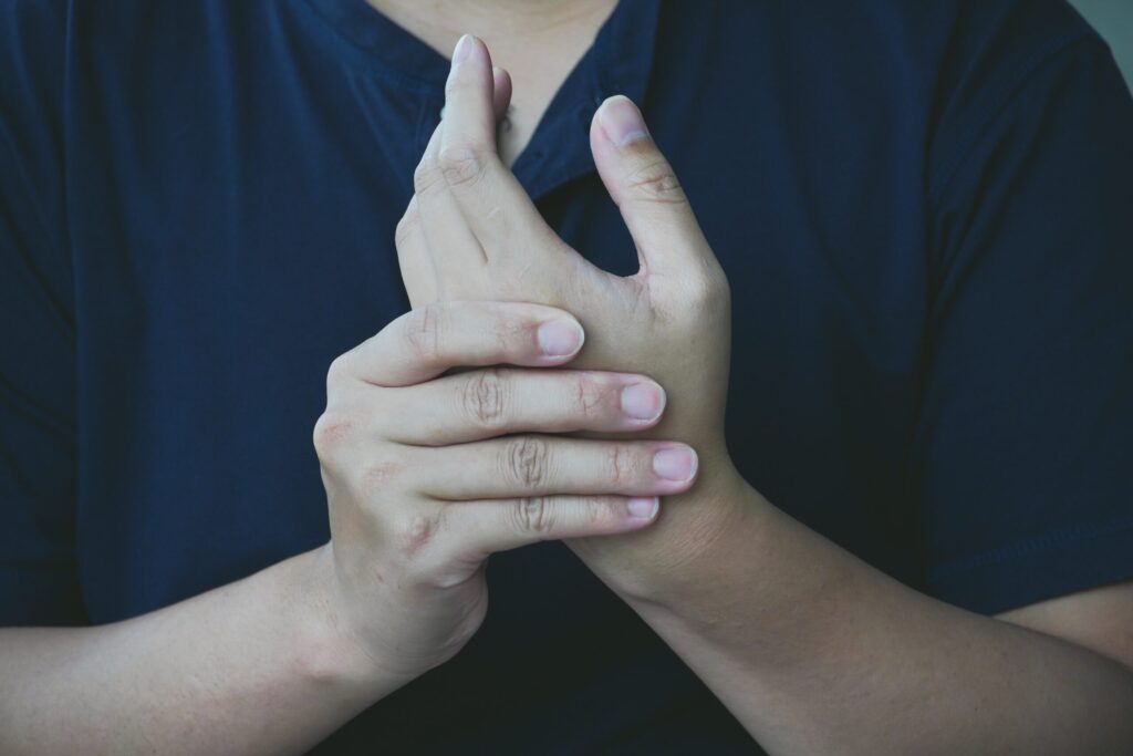Close-up of a hand grasping the wrist in discomfort, wrist pain relief offered at Mast Health chiropractic clinic in Tampa, FL