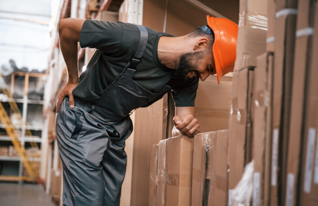 Man holding his lower back in pain from a work injury in Tampa FL