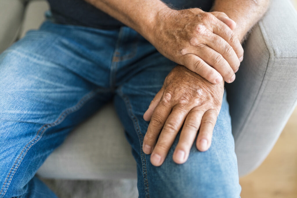 Close-up of a senior man's hand resting on his leg, nerve health in aging hands Mast Health assesses for neuropathy in Tampa