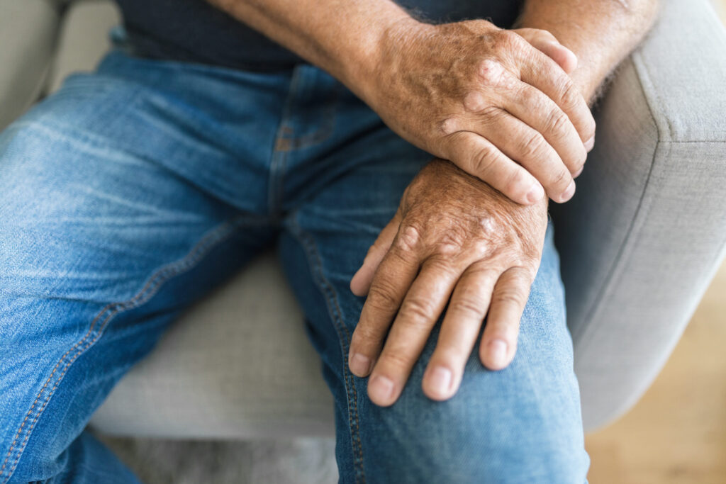 Close-up of senior hands resting on the legs, reflecting joint comfort supported by Mast Health chiropractic care in Tampa, FL