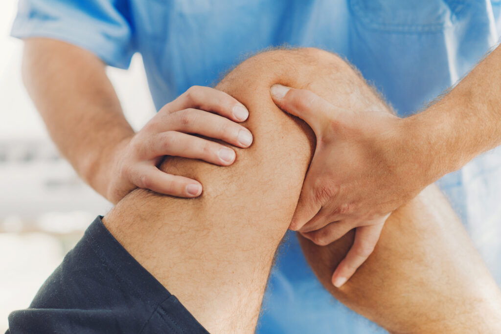 Therapist performing a hands on leg treatment for a patient's knee, knee pain Mast Health corrects at the source in Tampa