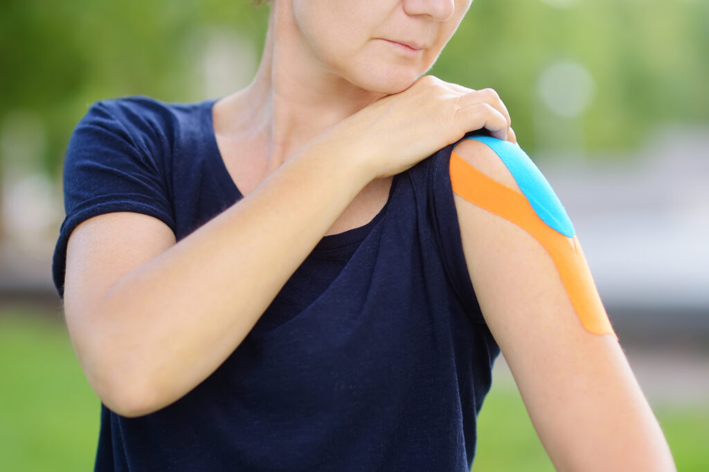 Woman with kinesiology tape applied to her shoulder for rotator cuff support at Mast Health in Tampa, FL