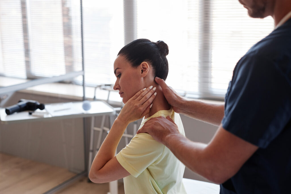 Chiropractor performing manual neck therapy on a female patient to relieve neck pain at Mast Health in Tampa, FL